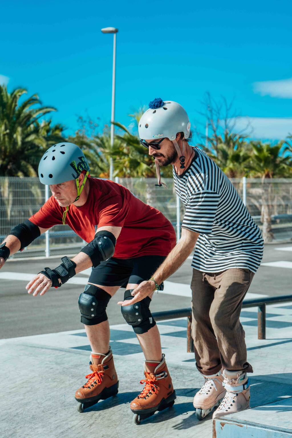 A coach holding a beginner’s hands as they roll forward