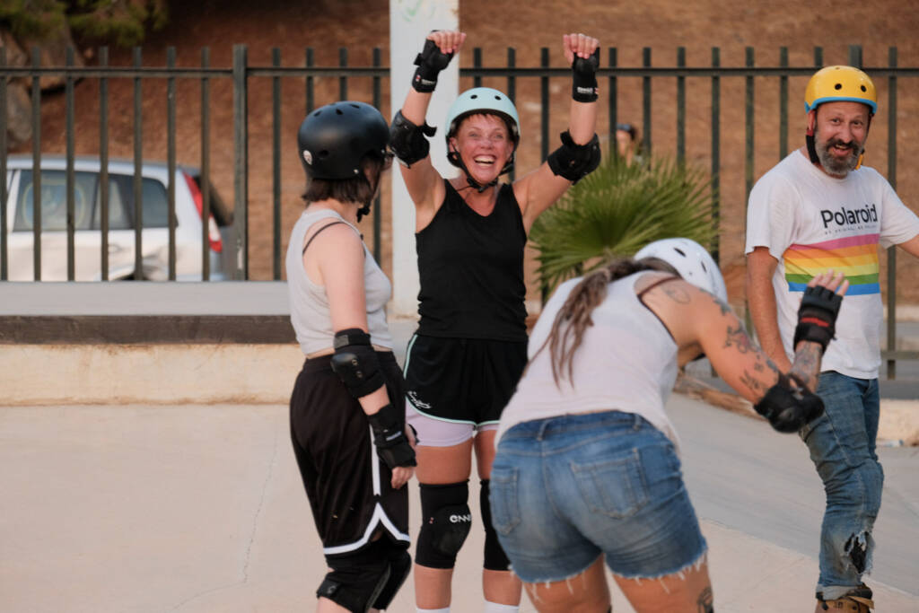 Skater raising her arms in celebration with friends