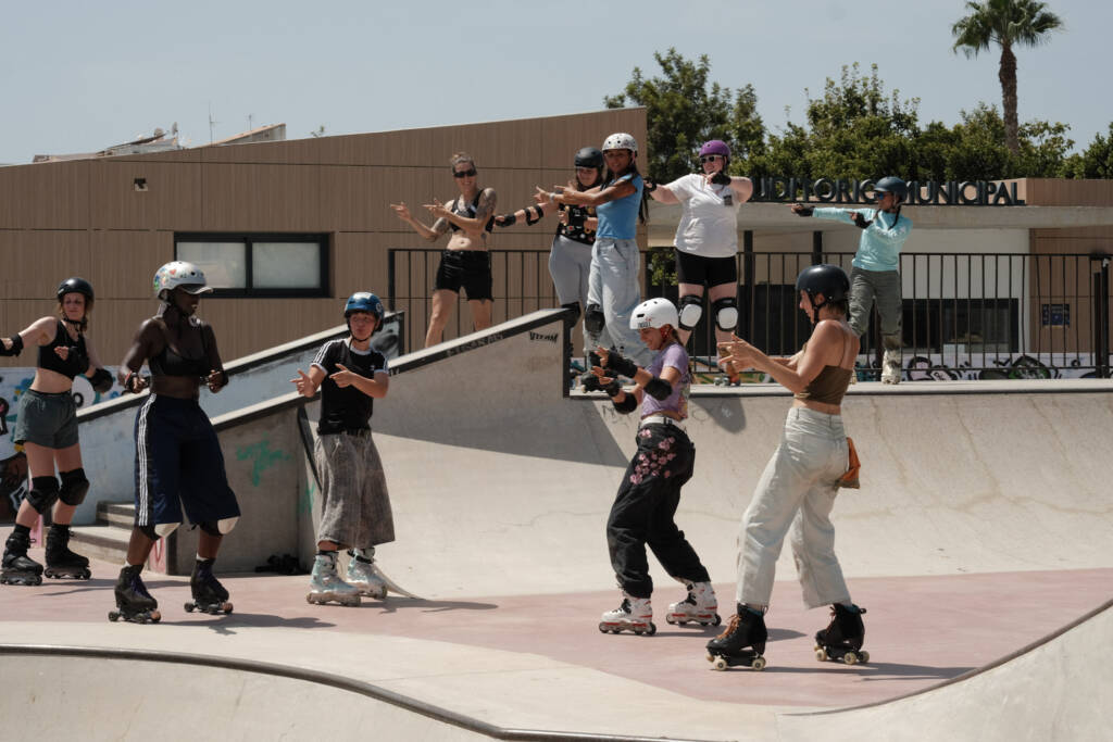 Group of skaters dancing together across the skatepark